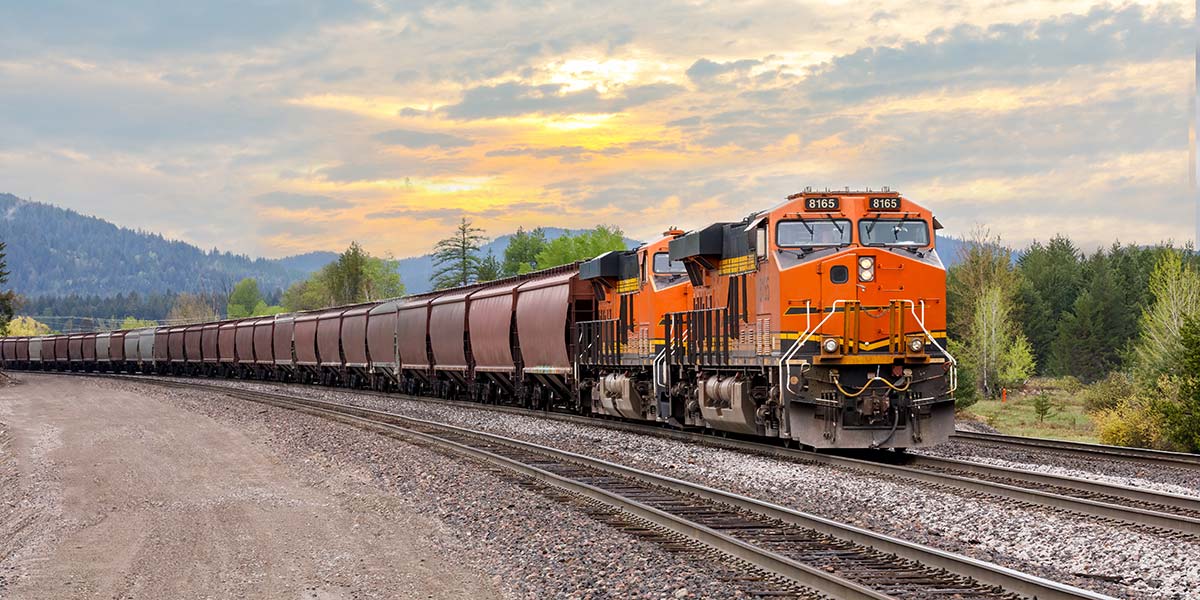 BNSF freight train hauling bulk railcars along a mainline track, illustrating how Class I railroads connect with short-line rail networks to move goods efficiently